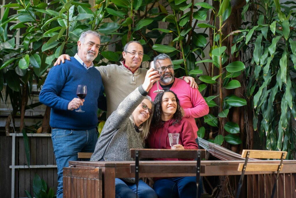 group of people over 50 middle age taking a photo with drinks, representing how some people want and choose this life and find meaning in it while others clearly do not want to be there