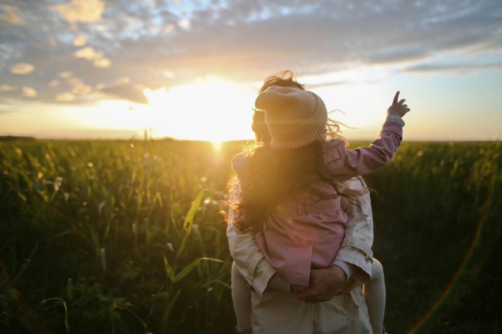 child and parent in field, that seems important feeling of home